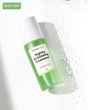 Green and white bottle of 'Nightly Exfoliating Treatment' with droplets on a light background